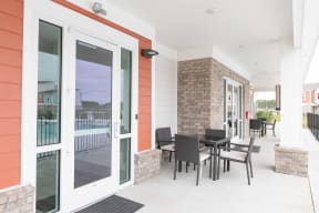 a patio with a table and chairs outside of a house