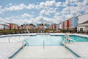 a swimming pool with an apartment building in the background