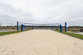 the volleyball court is equipped with a volleyball net and benches