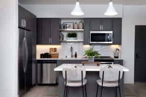 a kitchen with black cabinets and a table and chairs