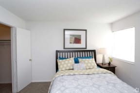 a white bedroom with a bed and a window