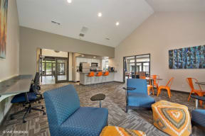 a clubhouse with blue chairs and a kitchen with a bar and a table