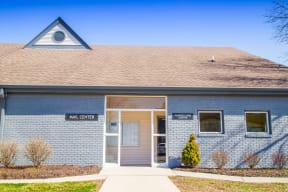 the front of a blue building with a door and a sign that reads mid center