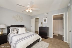 a bedroom with a bed and a ceiling fan