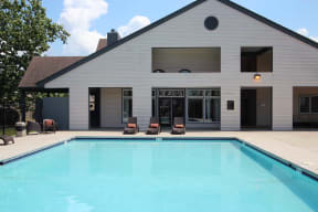 a swimming pool in front of a white house
