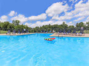 a large swimming pool with chairs and a paddle boat in it