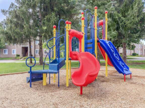 a playground with a blue slide and red and blue slides