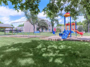 a childrens park with a playground and a swing set