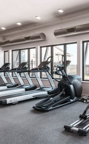 a gym with treadmills and other cardio equipment on the floor