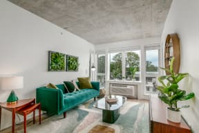 a living room with a green couch and a large window