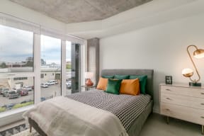 a bedroom with a bed and a large window