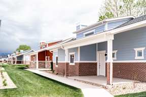 a row of houses with a sidewalk and grass