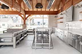 a large kitchen with stainless steel appliances and wooden ceilings