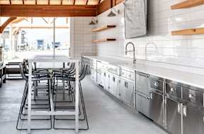 a large kitchen with stainless steel appliances and a table and chairs