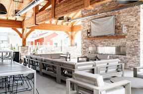 a restaurant with wooden tables and chairs and a brick wall