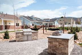 a backyard with a barbecue grill and hammocks