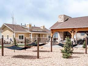 a backyard hammock area with a house in the background