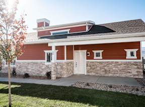 a red house with a white door and stone facade