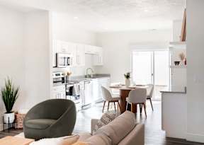 a living room and kitchen with a table and chairs