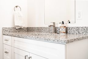 a white kitchen with granite counter tops and a sink