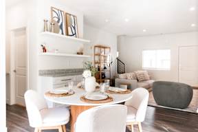 a living room and dining room with a table and chairs