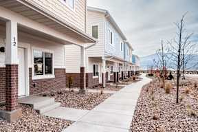 a row of houses with a sidewalk in front of them