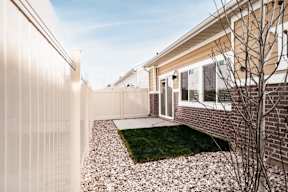 the front yard of a house with a white fence and grass