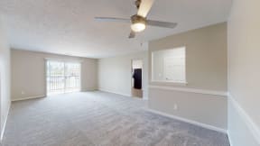 the living room and dining room of an empty home with a ceiling fan