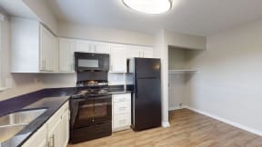 a kitchen with black appliances and white cabinets