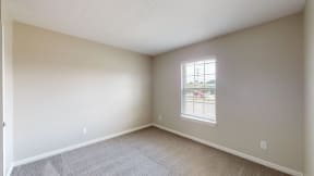 an empty room with carpet and a window