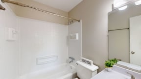 a bathroom with a tub and a sink and a toilet