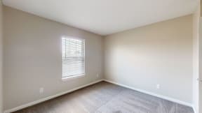 an empty room with carpet and a window