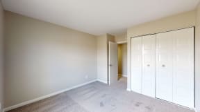 a bedroom with a closet and a door to a hallway