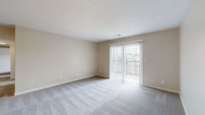 an empty living room with a door to a balcony