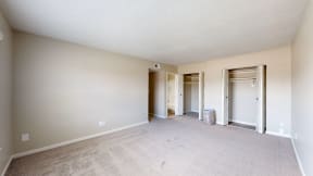 a spacious living room with a carpeted floor and a door to a hallway