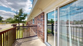 the balcony has a view of the parking lot and the street