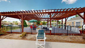 a chair sitting in front of a wooden pavilion with a playground