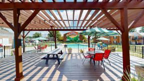 a covered patio with tables and chairs and a swimming pool