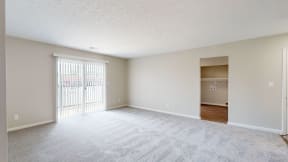 the spacious living room and dining room of an empty home with a sliding glass door