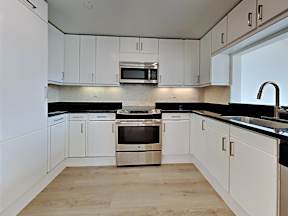a kitchen with white cabinets and stainless steel appliances at 1700 California Street, San Francisco, 94109