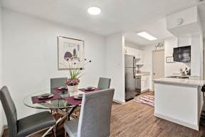 A modern dining room with a glass table and chairs.