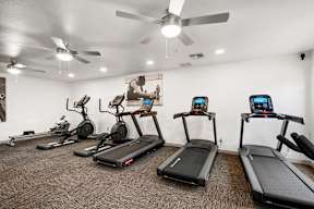 A gym with treadmills, exercise bikes, and elliptical machines.