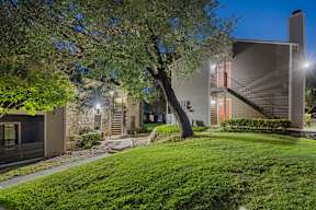 A modern house with a tree in front of it.