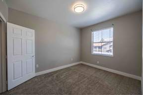 A room with a white door and a window with blinds.