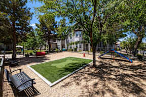 A playground with a slide, swings, and a bench.