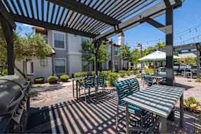 A patio with a table and chairs under a pergola.