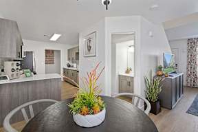 A modern kitchen with a dining table and chairs in the foreground.
