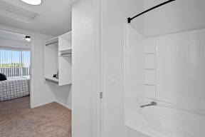 A white bathroom with a tub and a window.