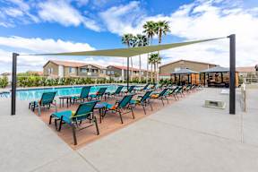 A row of sun loungers are set out on a concrete surface.