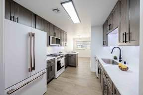 A modern kitchen with a white refrigerator and stainless steel appliances.